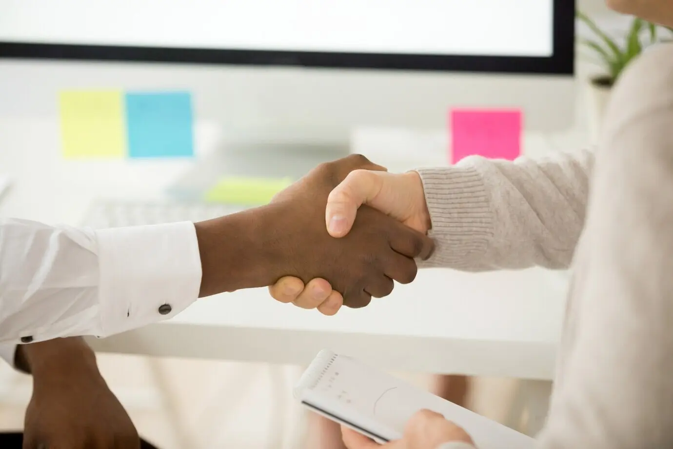 Межрасовое деловое рукопожатие как концепция помощи и поддержки в командной работе.